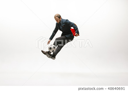 Businessman with football ball in office Businessman with football ball in office 48640691