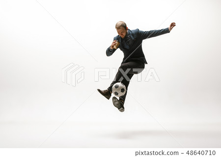 Businessman with football ball in office Businessman with football ball in office 48640710