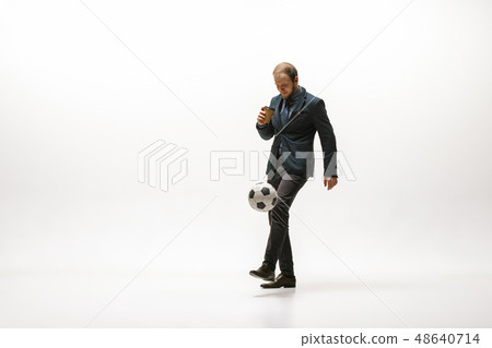 Businessman with football ball in office Businessman with football ball in office 48640714