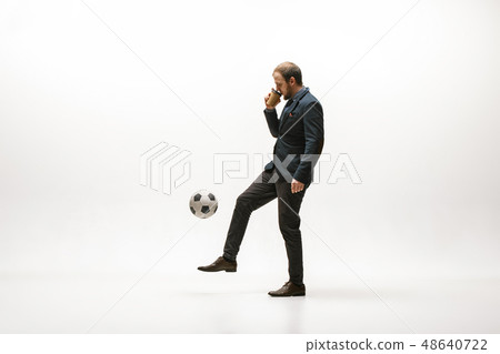Businessman with football ball in office Businessman with football ball in office 48640722