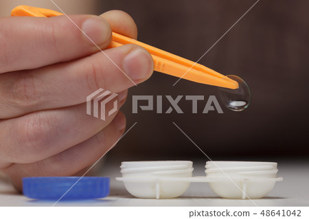 Girl takes out contact lens Girl takes out contact lens 48641042