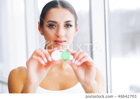 Health and Medicine. A Beautiful Young Oculist With A Smile Holds A Contact Lens Container. Eye Care 48642703