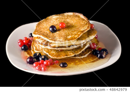 Pancakes with honey and currant. Black background. Selective focus. 48642979