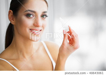Health and Beauty. Eye Care. Beautiful Young Woman Holding Drops For Eyes. Good Vision. Happy Girl Health and Beauty. Eye Care. Beautiful Young Woman Holding Drops For Eyes. Good Vision. Happy Girl 48643061