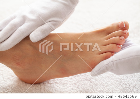 Hand and Nail Care. Beautiful Women's Feet with Pedicure in Beauty Salon. Master Doing Massage Feet Hand and Nail Care. Beautiful Women's Feet with Pedicure in Beauty Salon. Master Doing Massage Feet 48643569