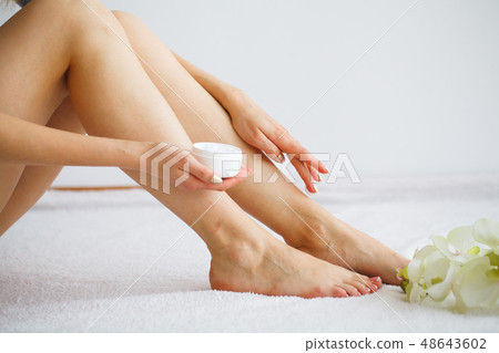 Hand and Nail Care. Beautiful Women's Feet with Perfect Pedicure. Beauty Day The Girl Holding Orchid 48643602