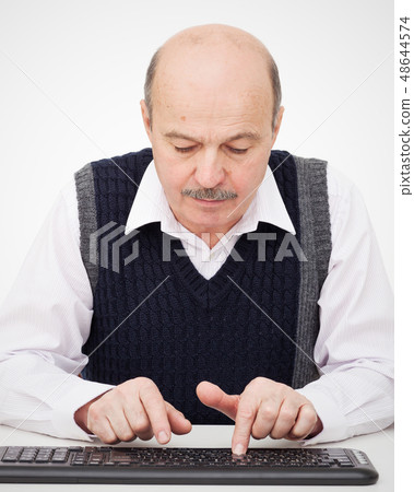 Elderly man learn to type on a keyboard Elderly man learn to type on a keyboard 48644574