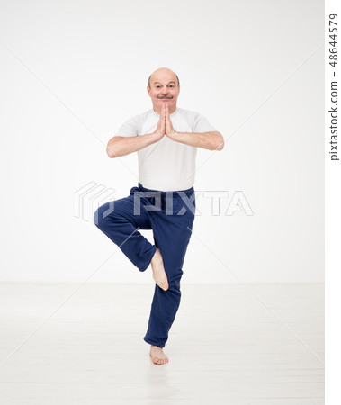Elderly man practicing yoga or fitness. Elderly man practicing yoga or fitness. 48644579