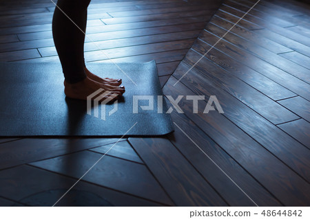 Girl standing on the mat, stretching toes Girl standing on the mat, stretching toes 48644842