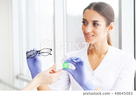 Health. Young Girl Holds Contact Lens In Hands. Portrait of a Beautiful Woman with Green Eyes and 48645083