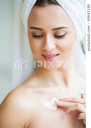 A beautiful woman using a skin care product, moisturizer or lotion and Skincare taking care of her 48645186