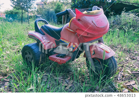 Worn red trycicle toy 48653013