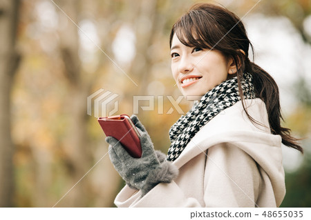 穿著外套冬天Sumaho公園的一名年輕日本婦女 48655035