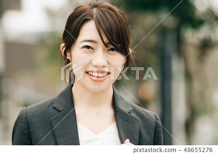 Business woman A young Japanese woman wearing a suit in the street 48655276