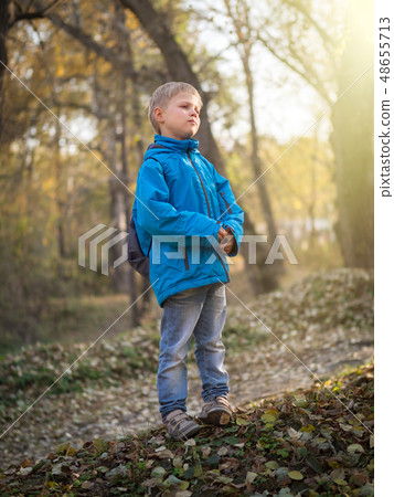 A 7-year-old boy is lit by the setting sun in an A 7-year-old boy is lit by the setting sun in an 48655713