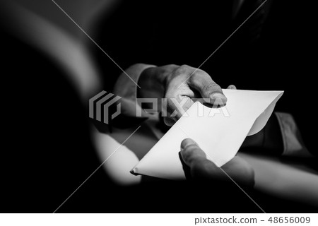 Businessman giving bribe money in the envelope to 48656009