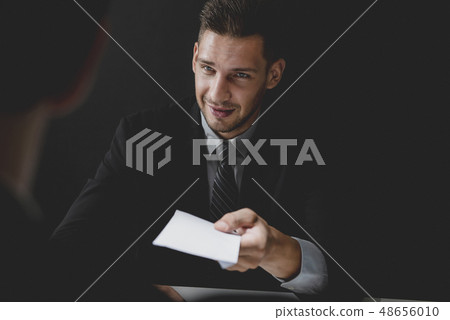 Businessman offering bribe money in the envelope Businessman offering bribe money in the envelope 48656010