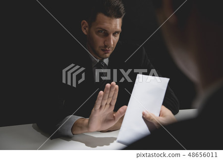 Businessman rejecting money in white envelope Businessman rejecting money in white envelope 48656011