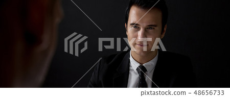 Man in shadow staring at interlocutor Man in shadow staring at interlocutor 48656733