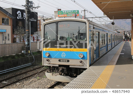 Blue train on railroad tracks with Mount Fuji 48657940