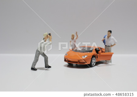 small figure with the toy sport car 48658315