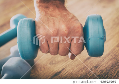 Man's hand with dumb-bells 48658565