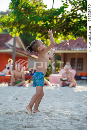 Boy playing Frisbee on the beach  48658680