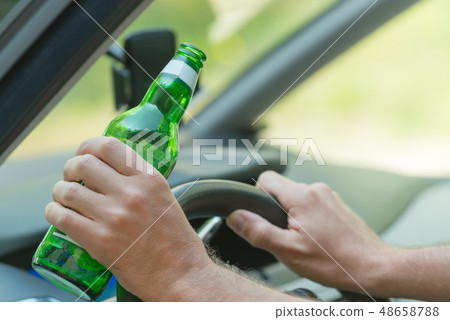 Man drinking beer in a car Man drinking beer in a car 48658788