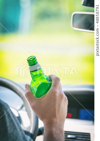 Man drinking beer while driving a car 48658791