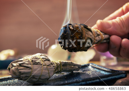 Man burning white sage incense 48658863