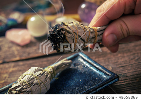 Man burning white sage incense 48658869