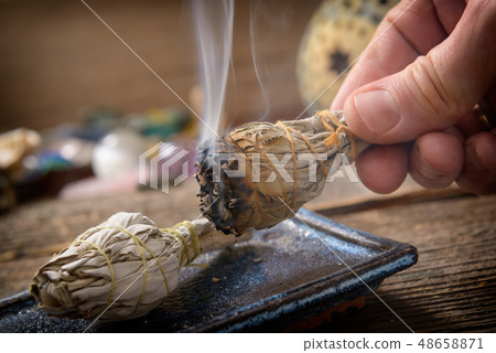 Man burning white sage incense 48658871