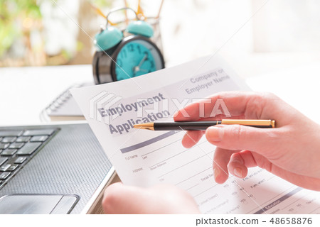 Holding blank employment application form Holding blank employment application form 48658876