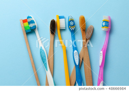 Colored toothbrushes on blue background. Colored toothbrushes on blue background. 48666984