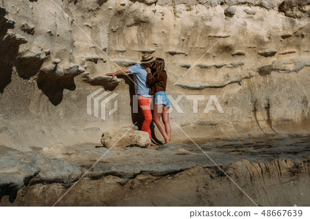 Couple in sunglasses kissing on the coastline 48667639