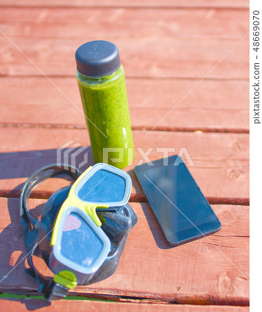 Swimming mask, bottle of smoothie and  smartphone 48669070