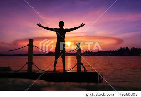 Asian man standing and jumping on floating pier Asian man standing and jumping on floating pier 48669302