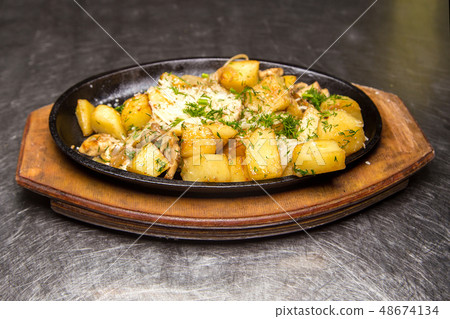 fried potatoes with meat in a frying pan fried potatoes with meat in a frying pan 48674134