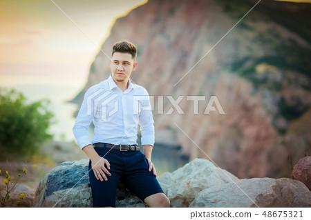 Happy young family pregnant pretty girl with husband on the cliff in mountains over sunset lights Happy young family pregnant pretty girl with husband on the cliff in mountains over sunset lights 48675321