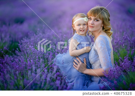 Mom and daughter in beautiful dresses in lavender field Mom and daughter in beautiful dresses in lavender field 48675328