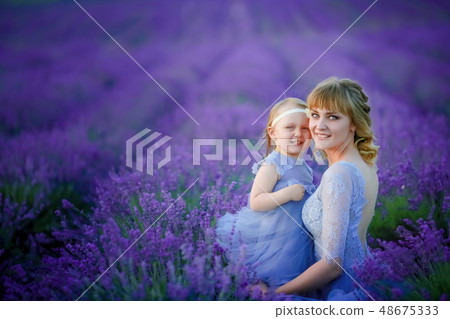 Mom and daughter in beautiful dresses in lavender field Mom and daughter in beautiful dresses in lavender field 48675333