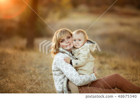 Mother hugging her child during walk in the park Mother hugging her child during walk in the park 48675340
