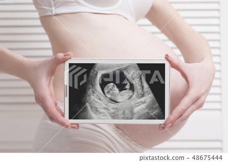 Pregnant woman in underwear holding and showing 48675444