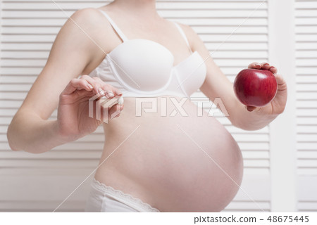 Pregnant woman in underwear holding 48675445