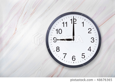 Wall clock show nine o'clock on marble texture. Office clock show 9pm or 9am Wall clock show nine o'clock on marble texture. Office clock show 9pm or 9am 48676365