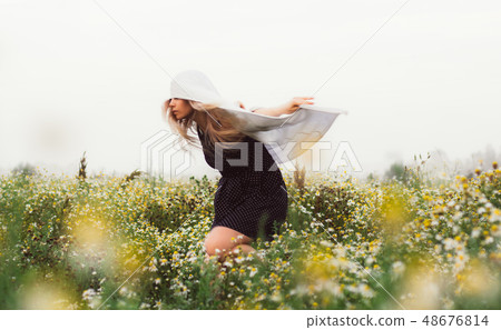 Portrait of young girl dancing in chamomile field 48676814