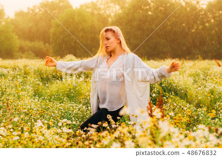 Portrait of young girl dancing in chamomile field 48676832