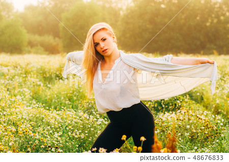 Portrait of young girl dancing in chamomile field 48676833