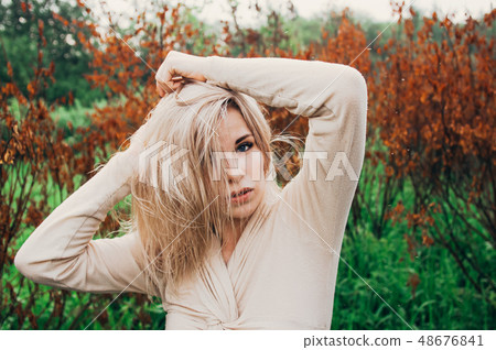 Portrait of young girl dancing between dead trees 48676841