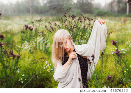 Portrait of young girl dancing in chamomile field 48676853